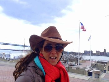 Young woman looking at flag against sky