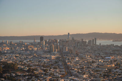 Aerial view of illuminated city against sky during sunset