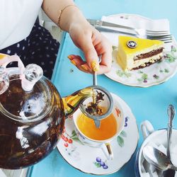 Midsection of woman pouring tea in cup