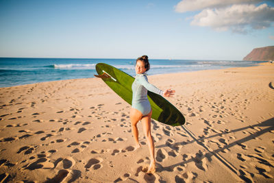 Woman on shore at beach against sky