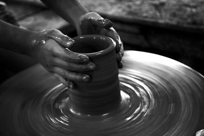 Cropped hands of woman molding mud