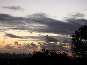 Silhouette of trees against cloudy sky