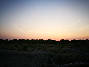 Scenic view of field against clear sky during sunset