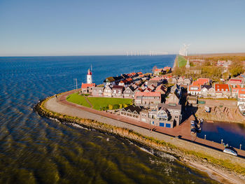 High angle view of buildings by sea against clear sky