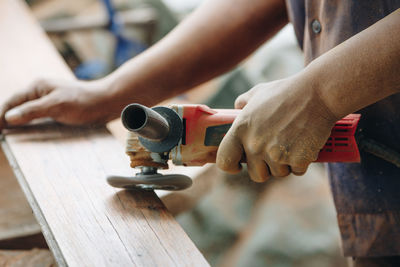 Midsection of man working on wood