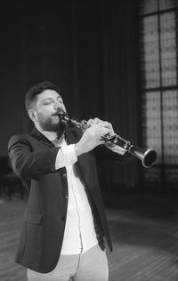 Man playing clarinet while standing at studio