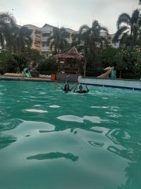 People in swimming pool against trees