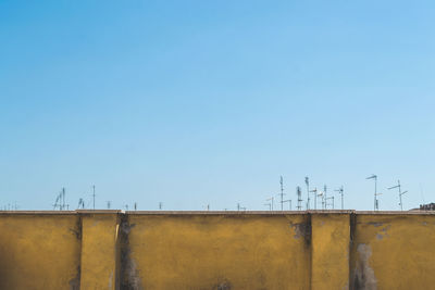 Low angle view of rooftop against clear blue sky