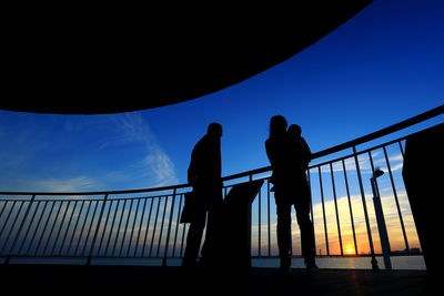 Silhouette people against clear sky during sunset