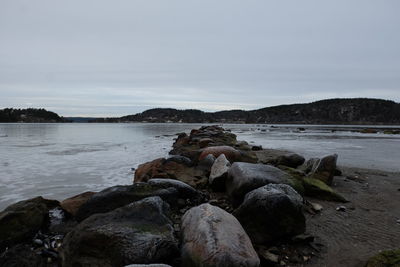 Rocks on beach against sky