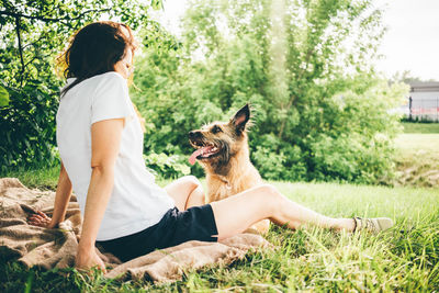 Side view of woman with dog on field