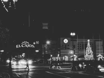 People walking on illuminated road at night