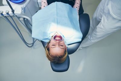 High angle view of girl lying at dentist office