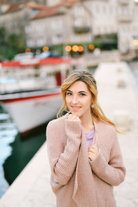 Portrait of young woman standing in city