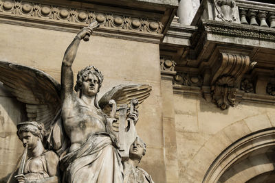 Low angle view of angel statue against historic building