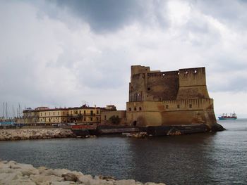 Building by sea against sky in city