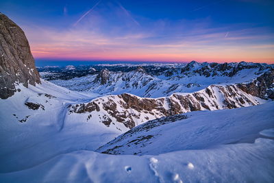 Scenic view of snow covered mountains against sky during sunset