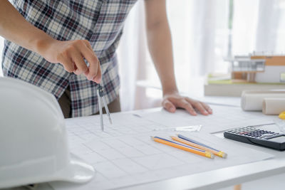 Midsection of man using laptop on table