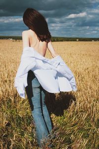 Rear view of woman standing on field