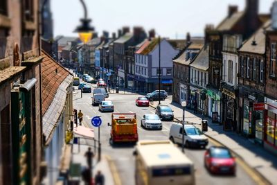 Traffic on city street by buildings against sky