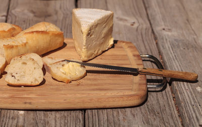 Close-up of cheese on bread at cutting board