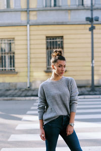 Portrait of a beautiful young woman standing on road