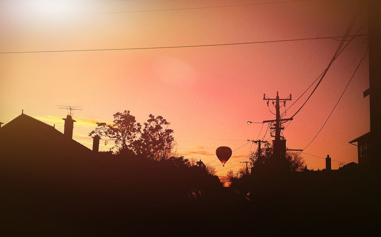 sunset, power line, silhouette, building exterior, electricity pylon, electricity, built structure, architecture, cable, power supply, sky, orange color, low angle view, tree, house, fuel and power generation, connection, power cable, street light, dusk