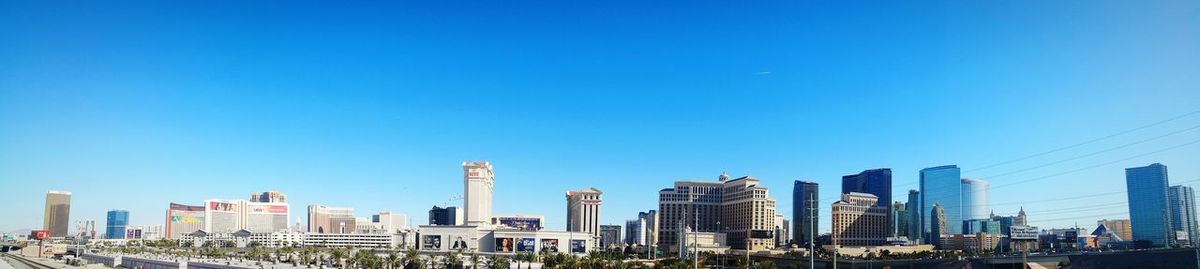 Urban buildings against clear blue sky