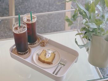 High angle view of coffee and dessert on table with vase