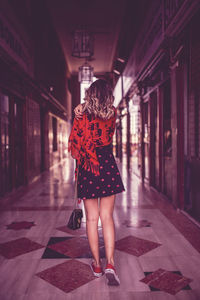 Rear view of woman standing on street in city