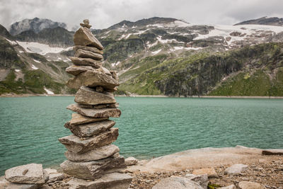 Stack of rocks against trees and mountain