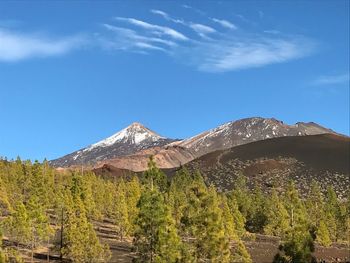 Scenic view of mountains against blue sky