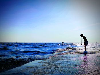 Man on beach against clear sky