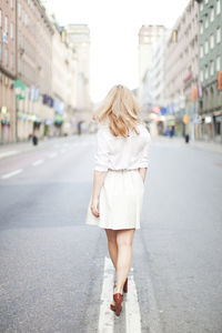 Woman walking on street, rear view