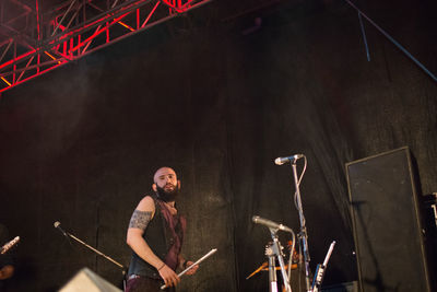 Full length of man with arms raised in background