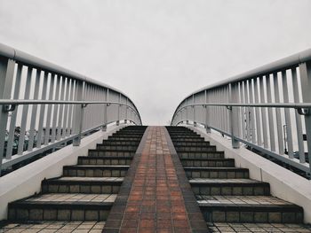 Low angle view of steps amidst buildings against sky