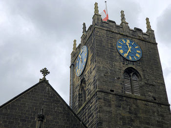 Low angle view of clock tower amidst buildings against sky