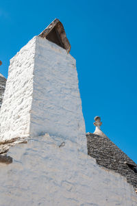 Low angle view of bird on building against sky