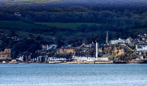 Scenic view of sea by city against mountain