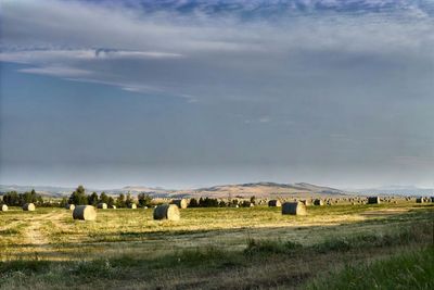 Hay bales on field against sky