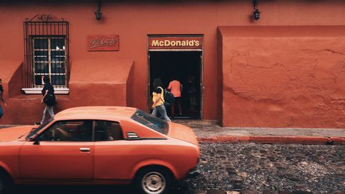 Reflection of man on car in city