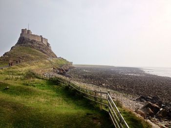 View of hill and fort next to sea