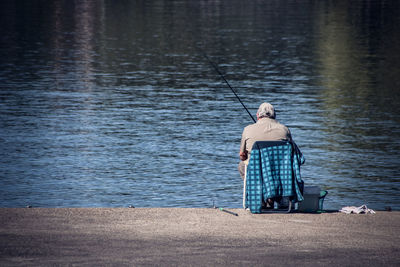 Rear view of senior man fishing in lake