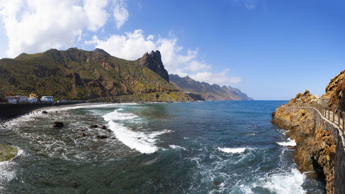 Scenic view of sea and mountains against sky