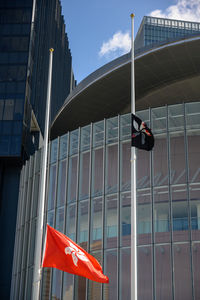 Low angle view of modern glass building against sky