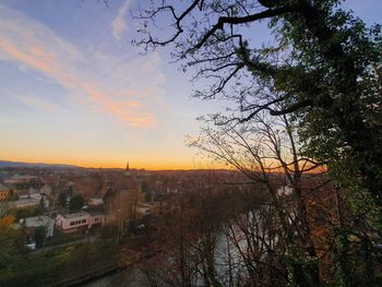 High angle view of trees and buildings against sky at sunset