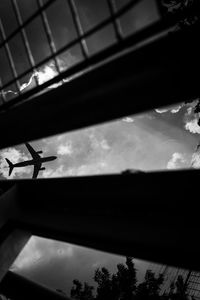 Low angle view of silhouette airplane against sky