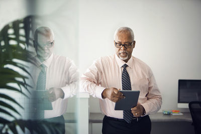 Doctor using tablet computer while standing hospital lobby