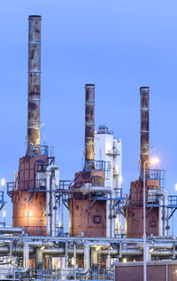 Low angle view of factory against clear sky at night