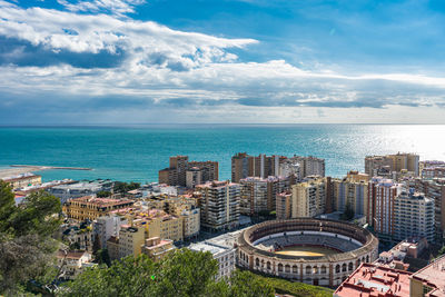High angle view of buildings by sea against sky